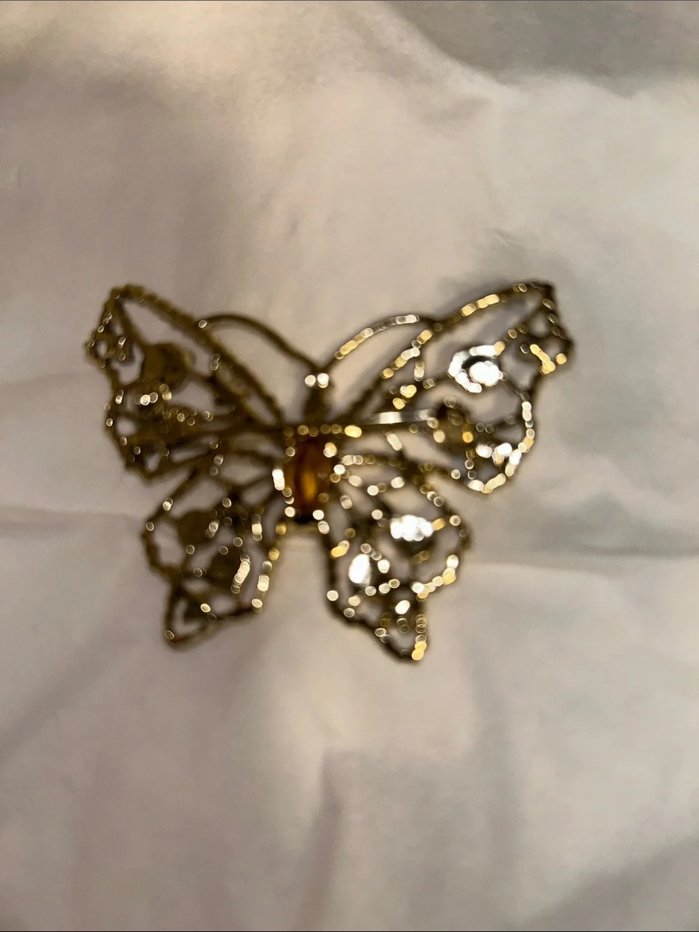 Dodds filigree butterfly brooch featuring a large amethyst-colored center stone